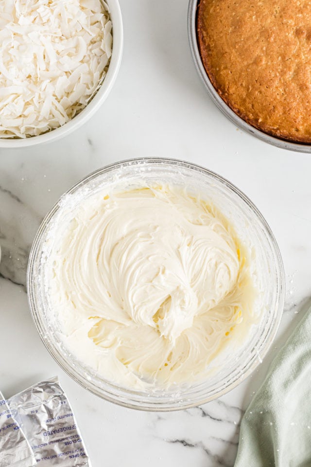 Overhead view of cream cheese frosting in glass mixing bowl