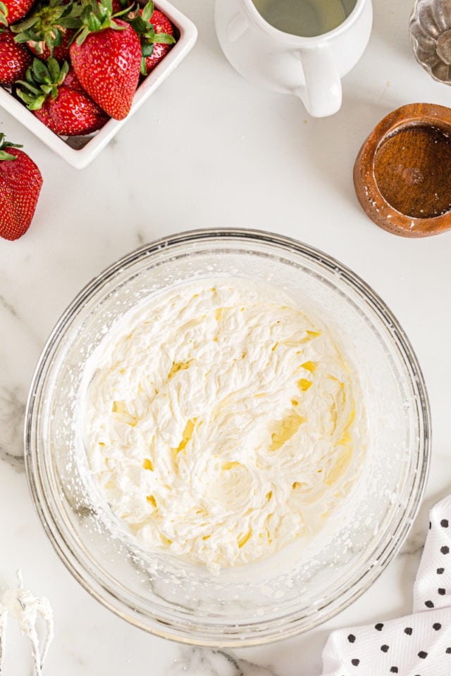 Overhead view of whipped cream in glass mixing bowl