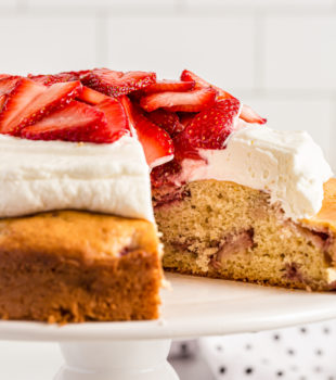 Lemon-Strawberry Shortcake on cake stand with one slice removed