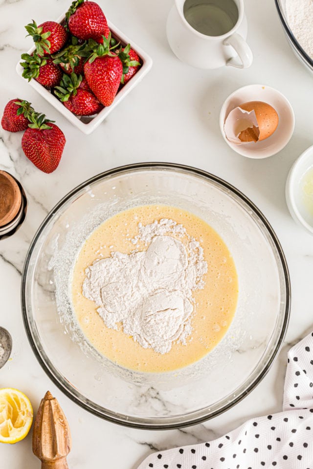 Overhead view of dry ingredients added to wet cake ingredients