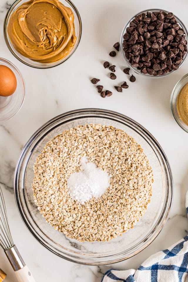 Overhead view of dry cookie ingredients in glass mixing bowl