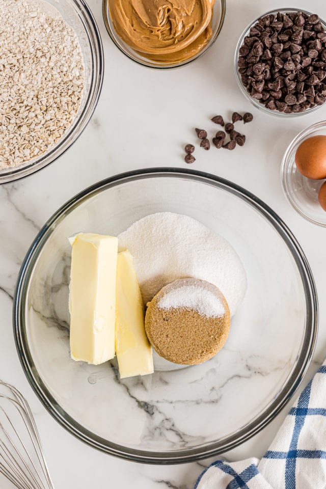 Overhead view of butter and sugar in glass mixing bowl