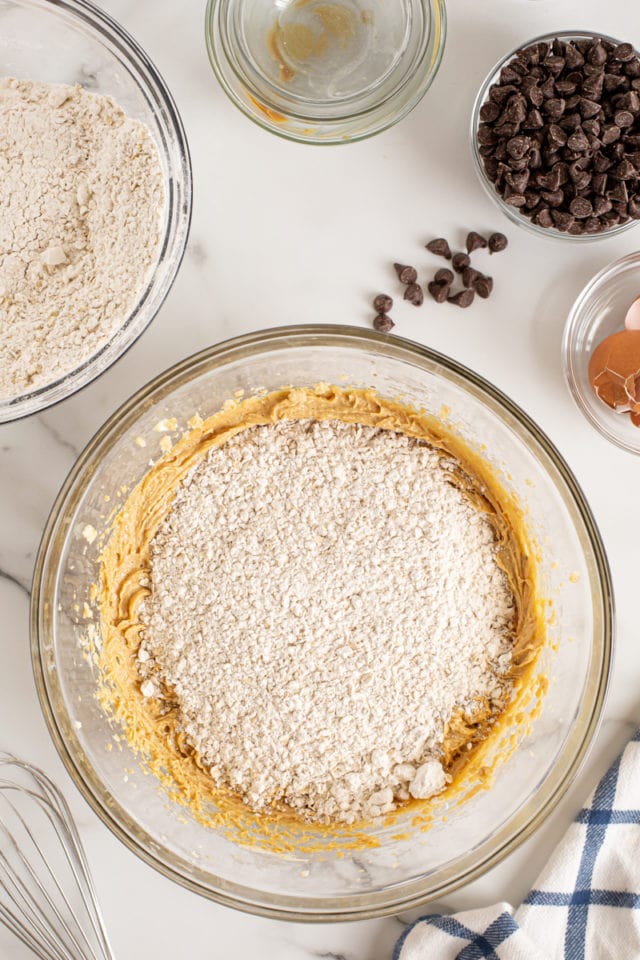 Overhead view of dry ingredients added to wet cookie ingredients