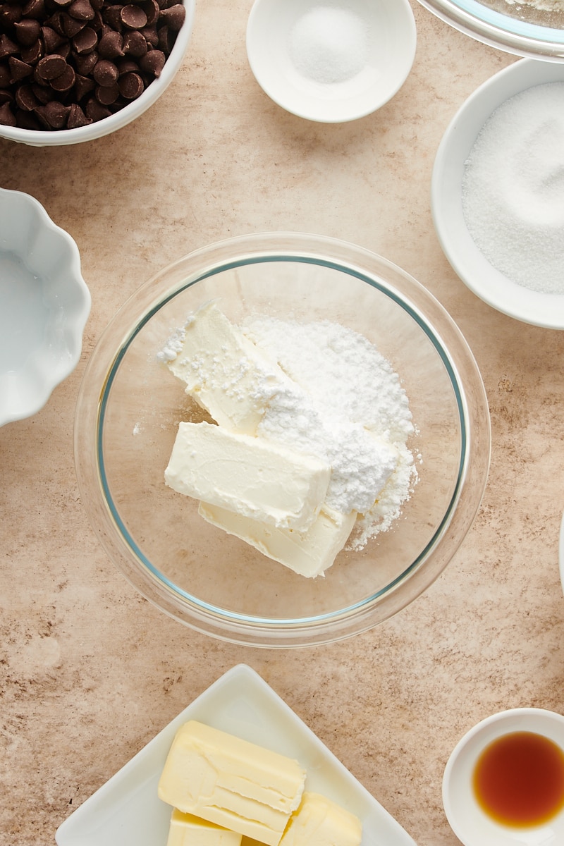 overhead view of cream cheese and confectioners' sugar in a glass bowl