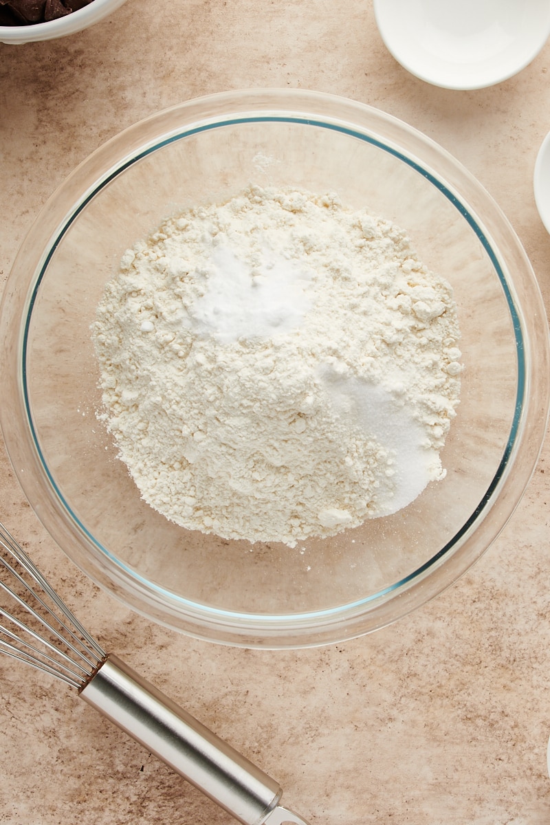 overhead view of flour, baking soda, and salt in a glass mixing bowl