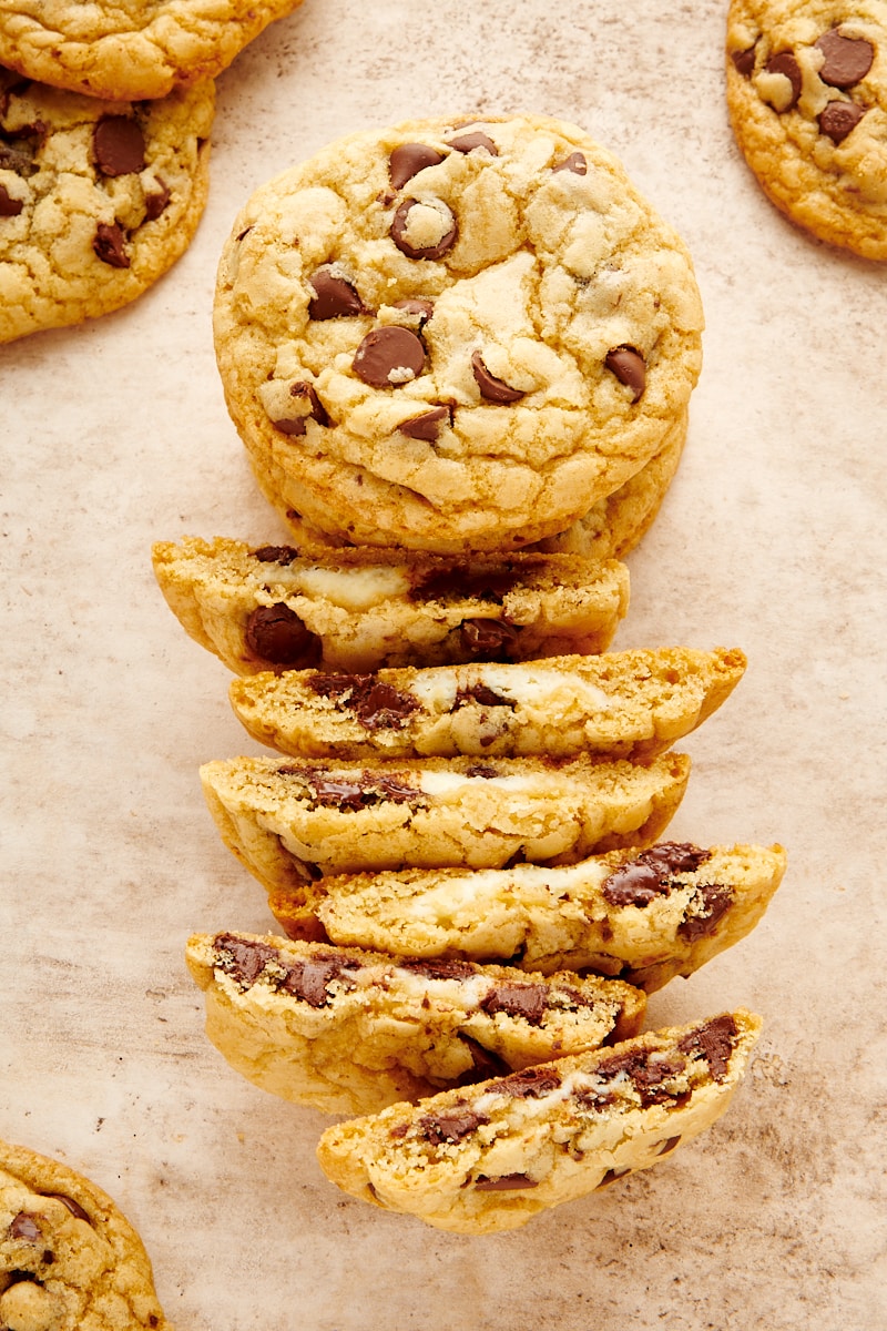 overhead view of a stack of Cheesecake-Stuffed Chocolate Chip Cookies and several cookies split in half