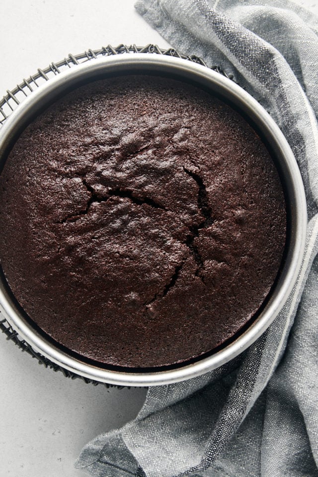 Overhead view of cocoa cake in baking pan set on wire rack