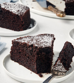 Cocoa cake slices on plates, with bite of cake on fork