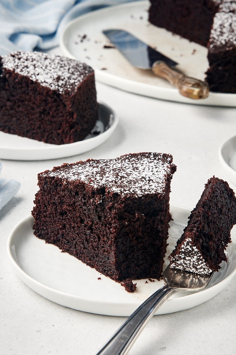 Cocoa cake slices on plates, with bite of cake on fork