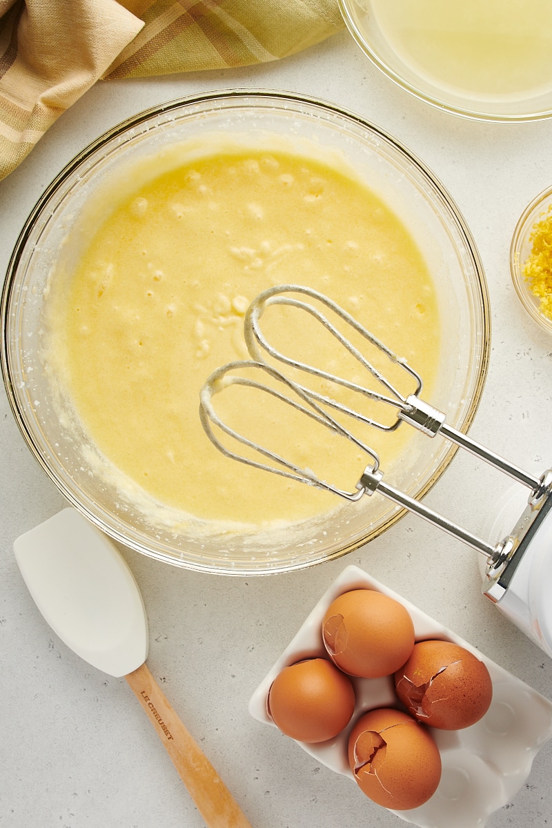 overhead view of butter, sugar, and eggs mixed in a glass mixing bowl