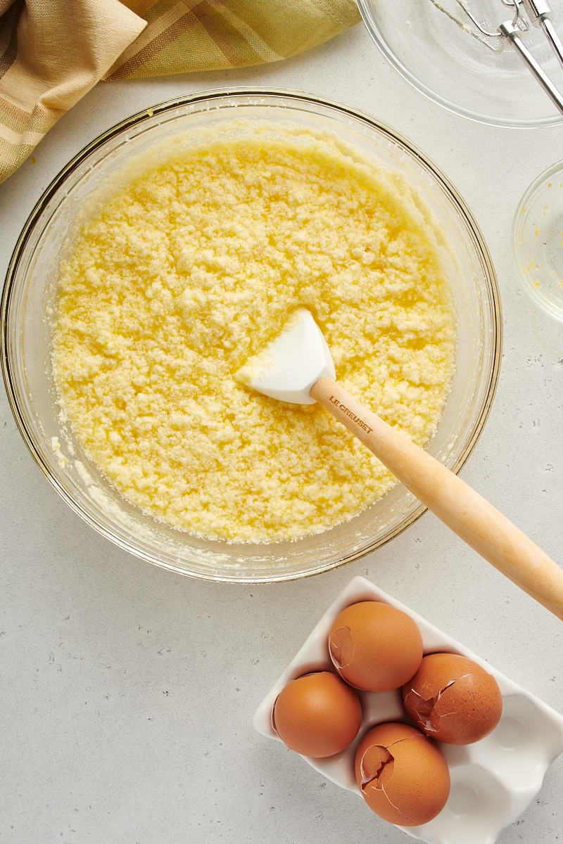 overhead view of mixed lemon curd mixture in a glass mixing bowl