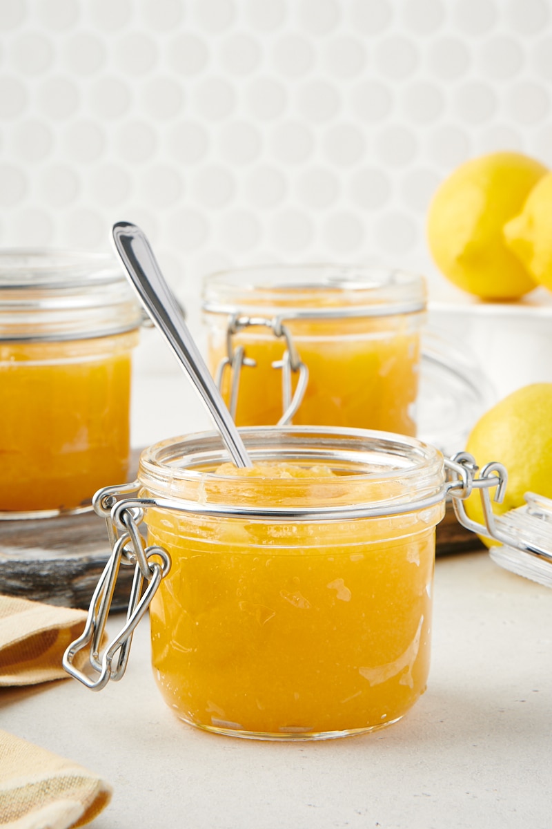 small glass jar of lemon curd with a spoon
