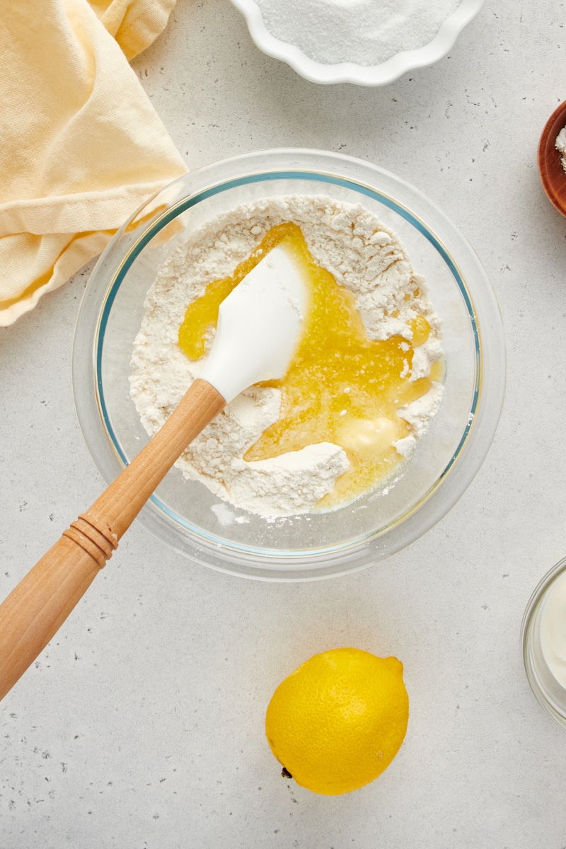 overhead view of flour, sugar, salt and melted butter in a glass mixing bowl