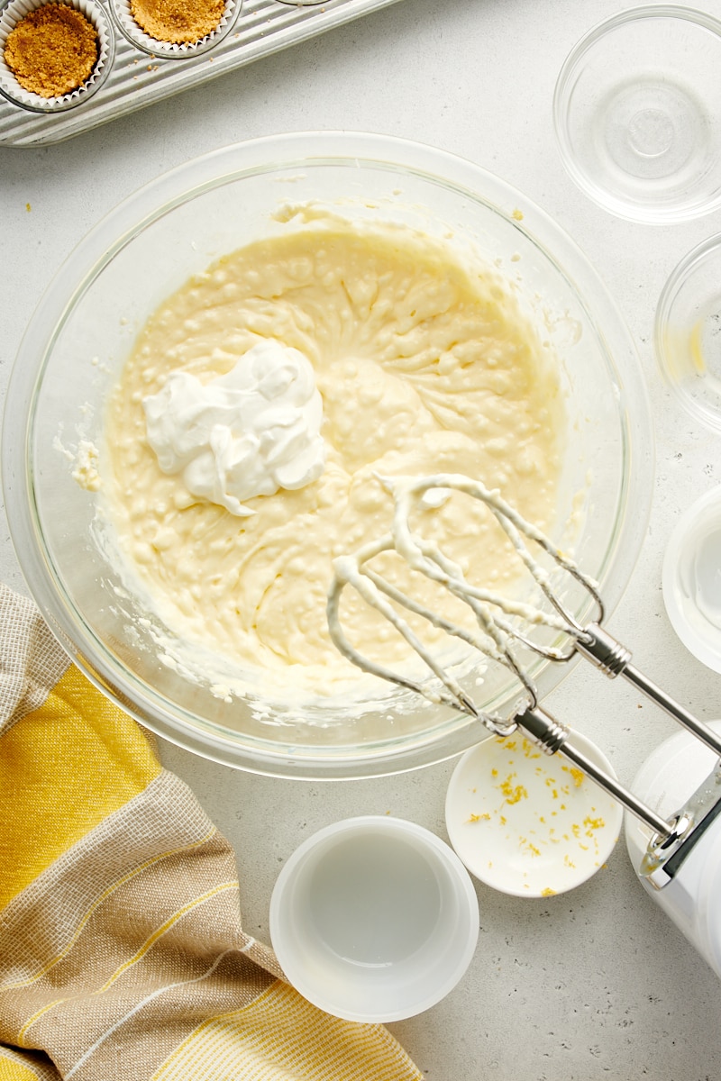 overhead view of cheesecake filling with sour cream added
