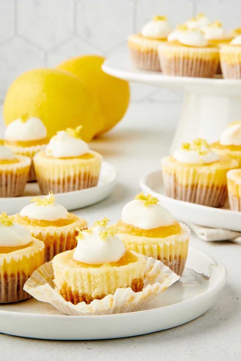 Mini Lemon Cheesecakes on small white plates and a white cake stand