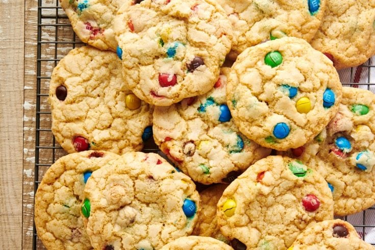Overhead view of M&M cookies stacked on wire rack