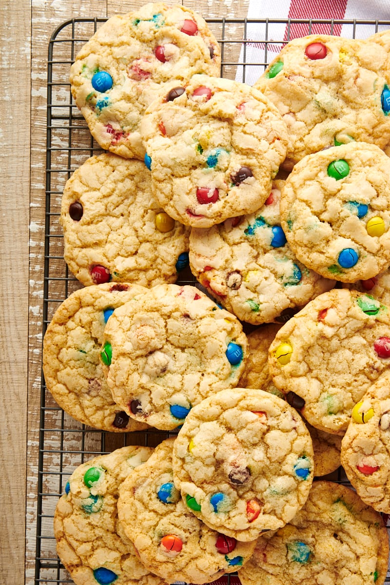 Overhead view of M&M cookies stacked on wire rack