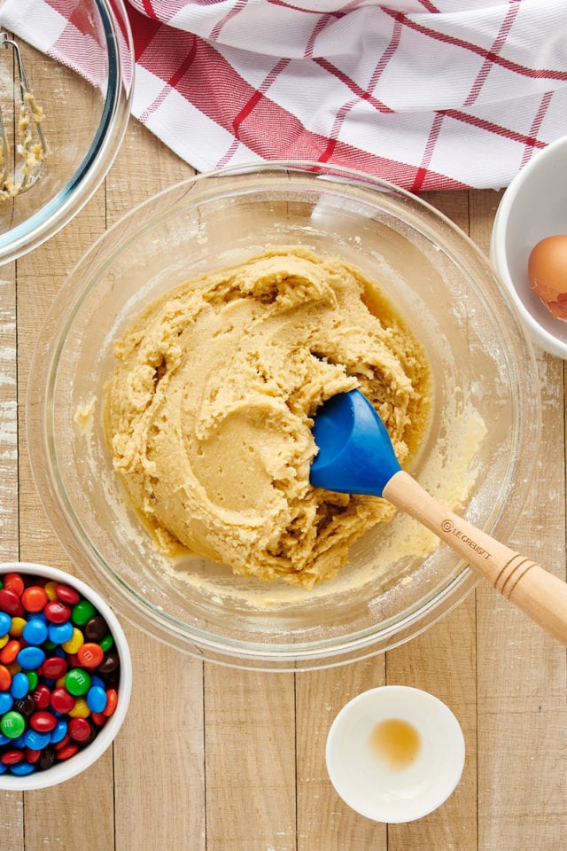 Cookie dough in glass mixing bowl with spatula
