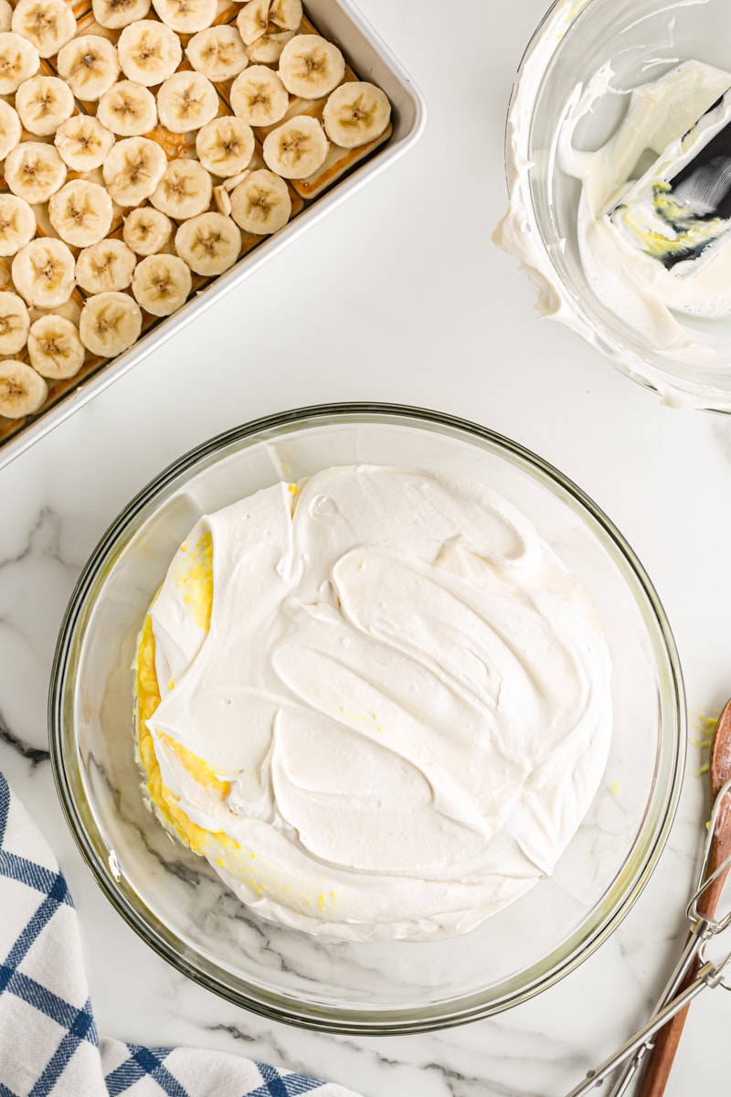 Overhead view of banana pudding mixture in glass mixing bowl