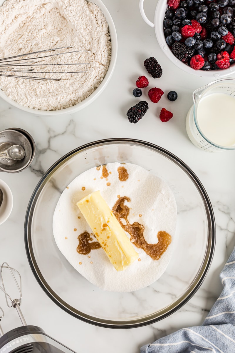 Overhead view of sugar, butter, and vanilla in mixing bowl