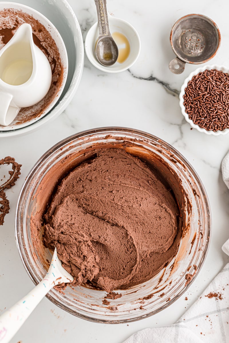 overhead view of chocolate buttercream in a glass mixing bowl