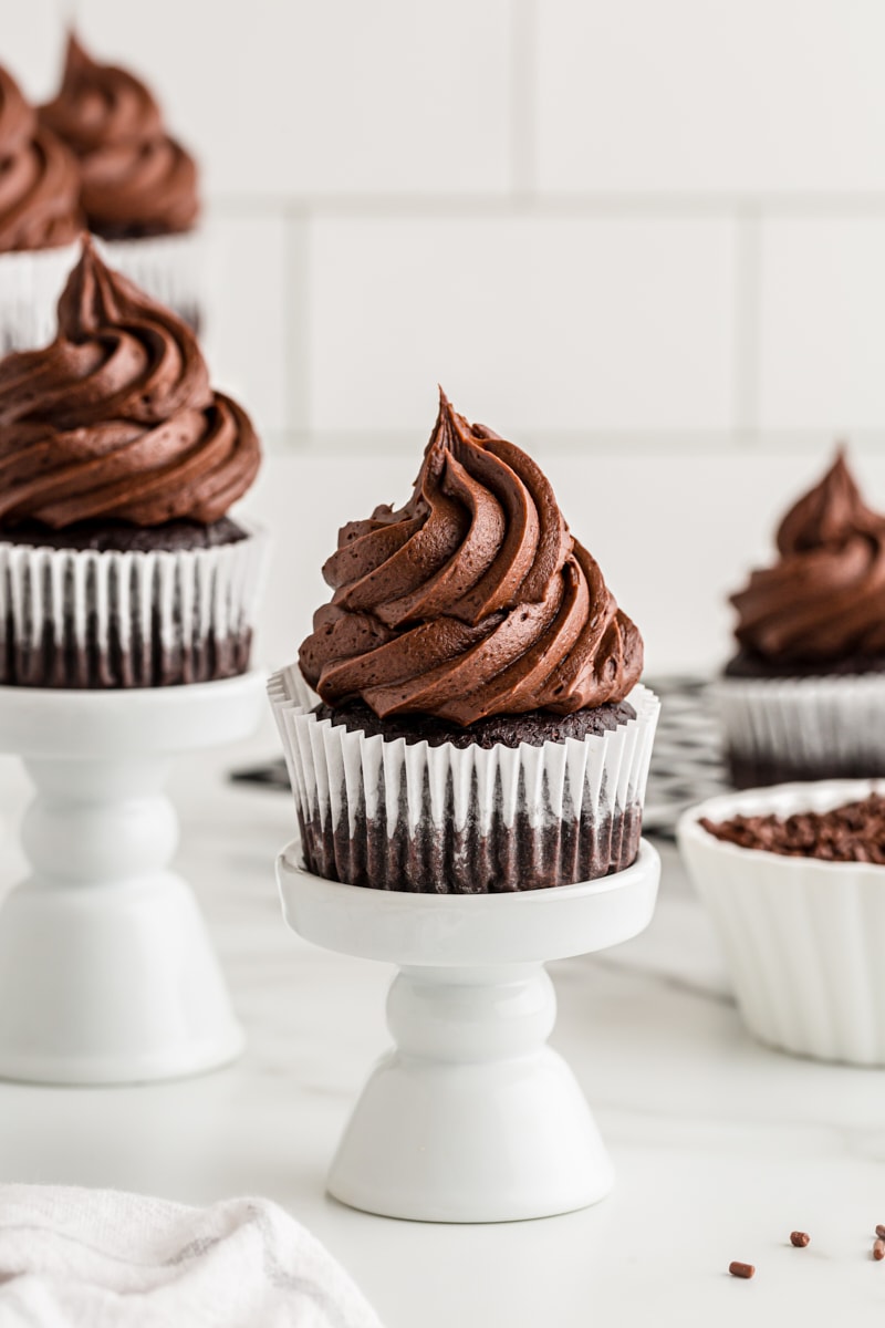 frosted chocolate cupcakes on small white cupcake stands
