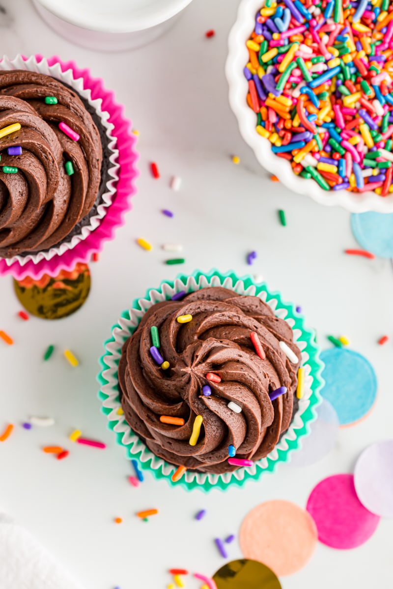 overhead view of chocolate cupcakes topped with rainbow sprinkles