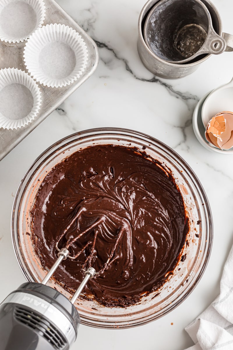 overhead view of mixed chocolate cupcake batter in a glass mixing bowl