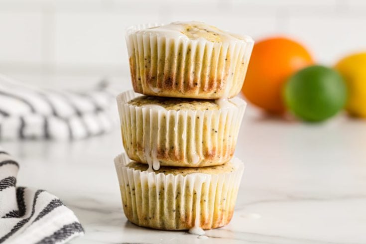 Stack of 3 citrus poppy seed muffins with glaze dripping down sides