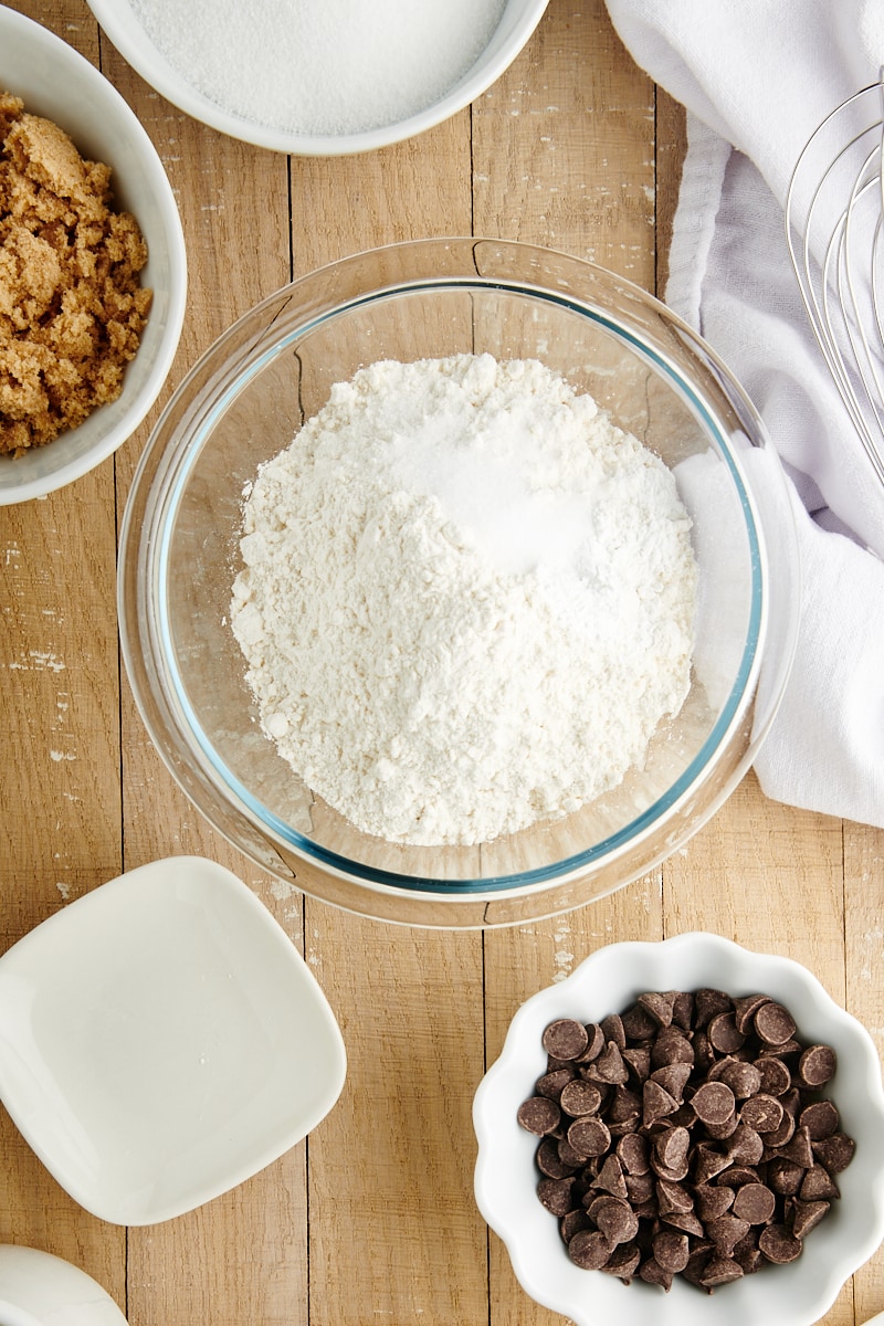 overhead view of flour, baking powder, and salt in a glass mixing bowl