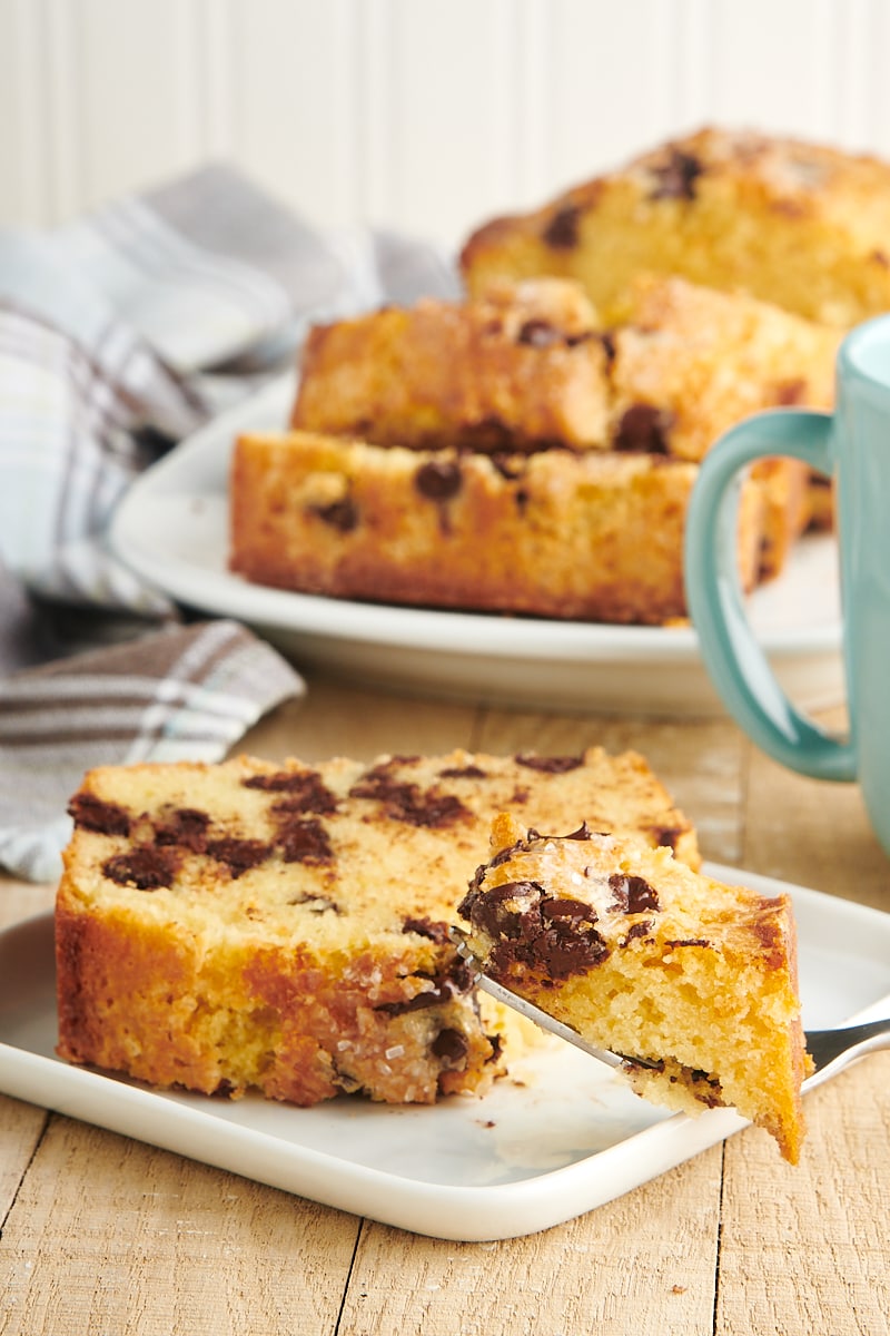 slice of Chocolate Chip Loaf Cake on a white plate with a bite on a fork