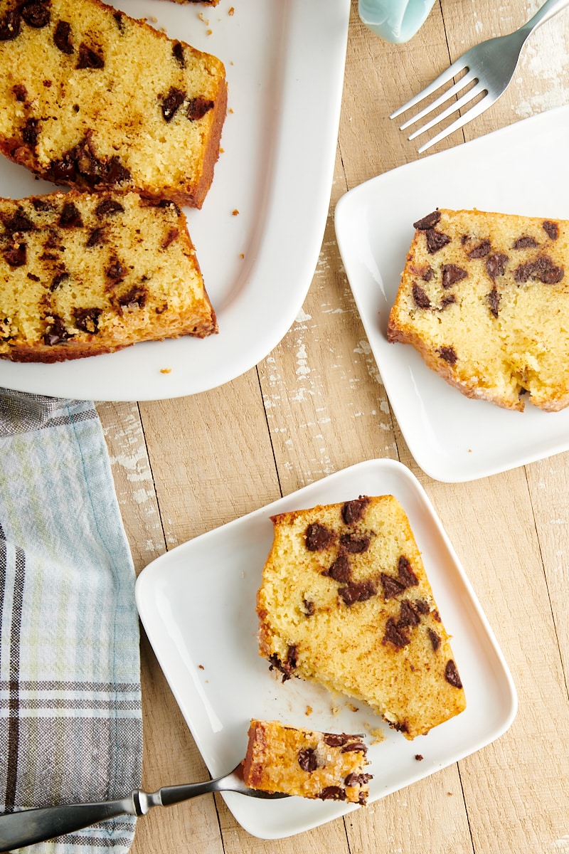 slices of Chocolate Chip Loaf Cake on white plates and a white serving tray