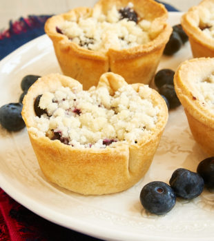 Closeup of mini blueberry cream cheese pies on plate