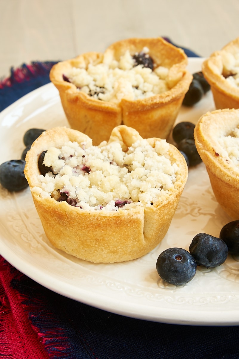 Closeup of mini blueberry cream cheese pies on plate.