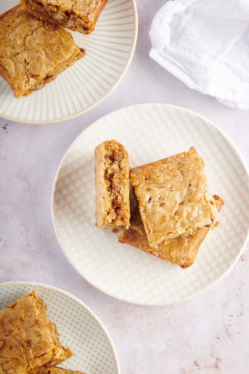 overhead view of three blondies on a white and beige plate