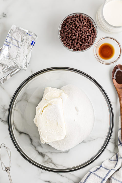 Cream cheese and sugar in glass mixing bowl