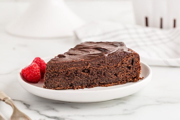Flourless chocolate cake on plate with raspberries