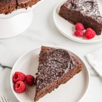 Two plates of flourless chocolate cake with raspberries