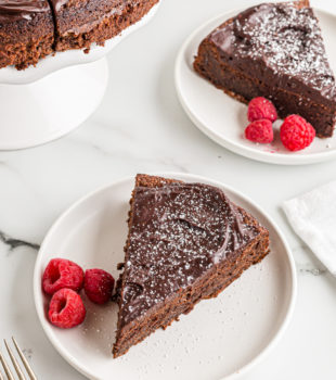 Two plates of flourless chocolate cake with raspberries