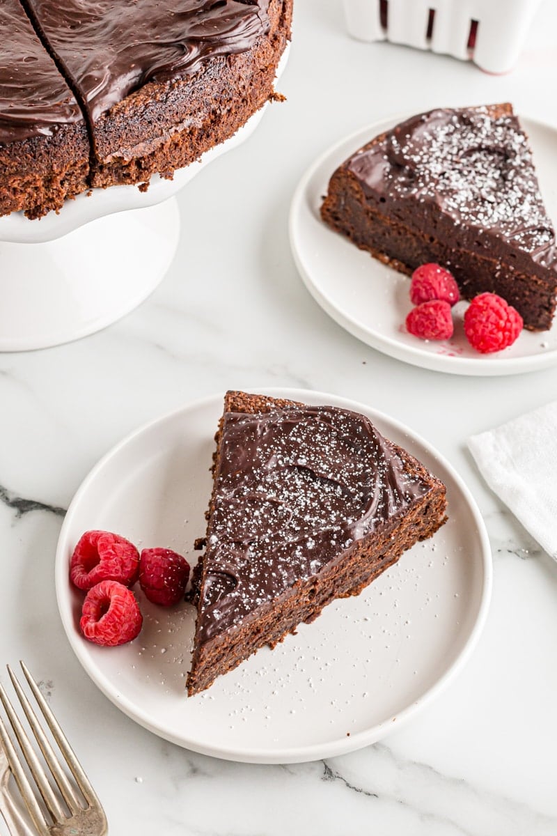 Two plates of flourless chocolate cake with raspberries
