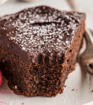Closeup of flourless chocolate cake on plate with tip eaten