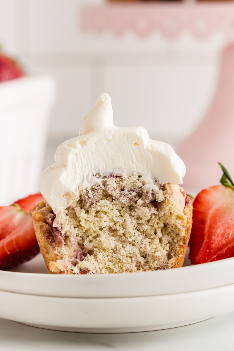 Halved strawberry cupcake on plate with strawberries