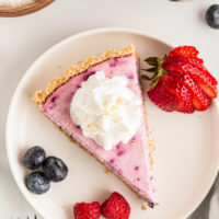 Overhead view of triple berry no-bake cheesecake on plate with fresh berries