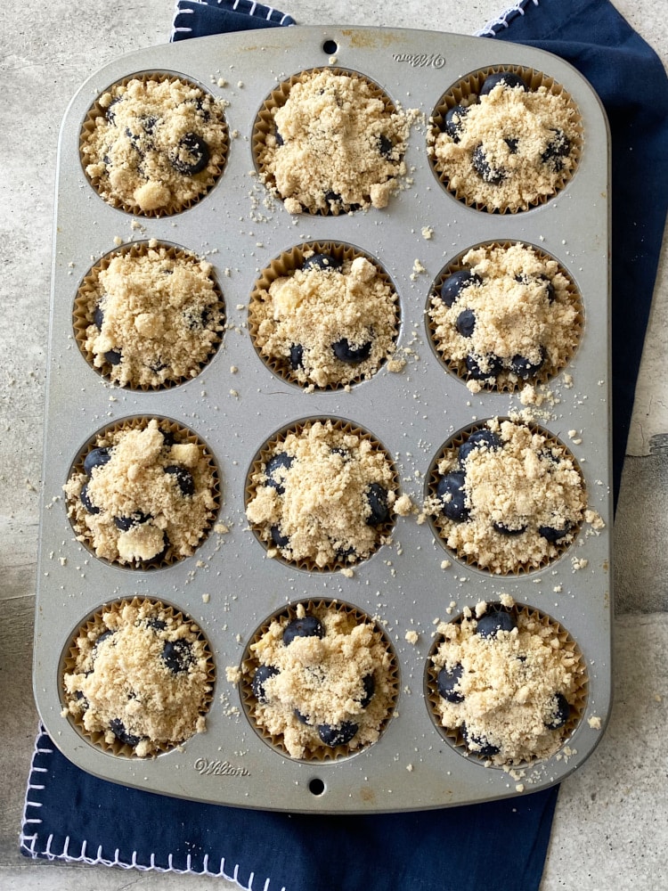 overhead view of blueberry coffee cake muffins in a muffin pan ready to go into the oven