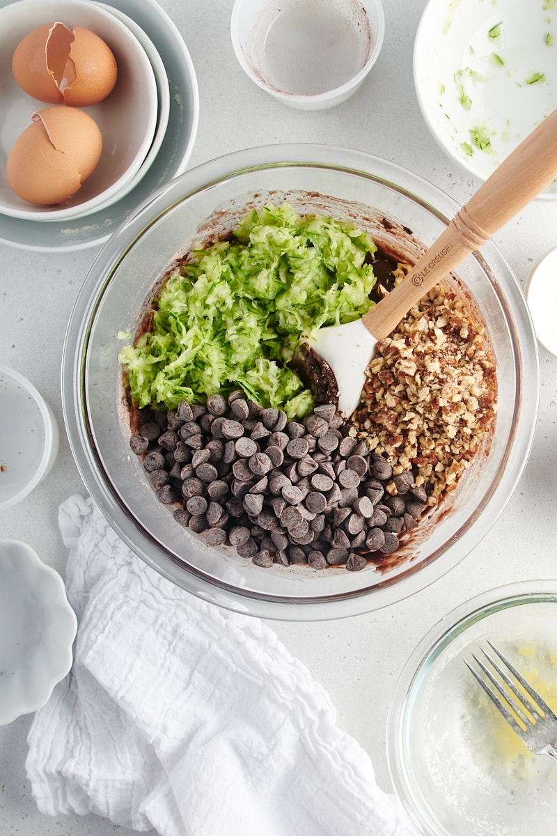 overhead view of zucchini, chocolate chips, and nuts added to quick bread batter