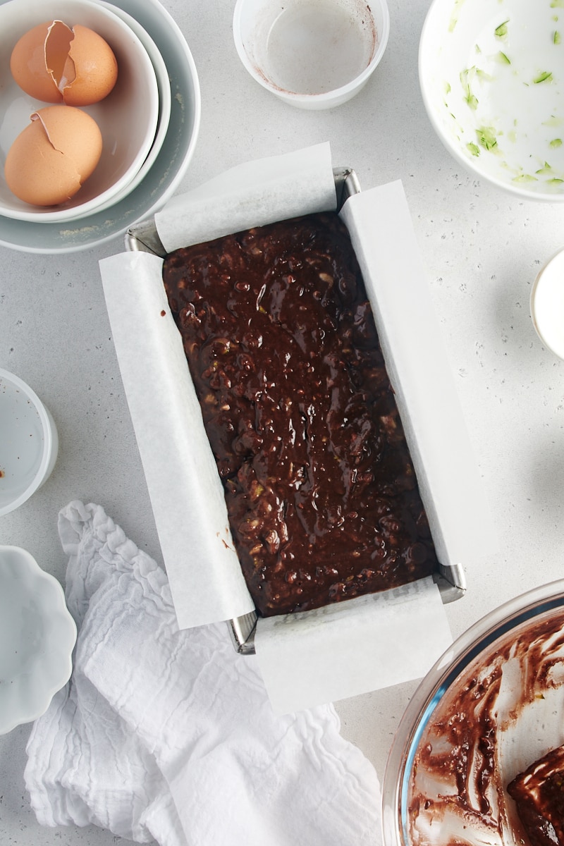 overhead view of Chocolate Zucchini Bread batter in a parchment-lined loaf pan