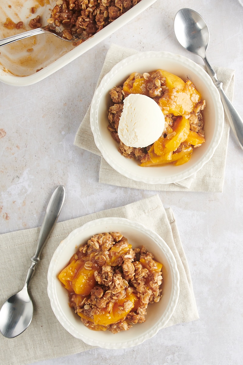 overhead view of two white bowls filled with peach crisp