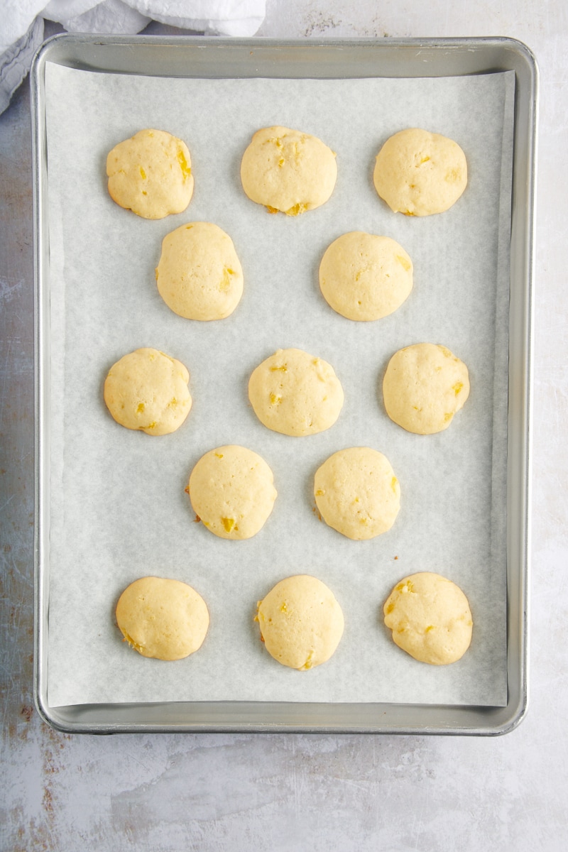 overhead view of freshly baked Pineapple Cream Cheese Cookies on a lined baking sheet