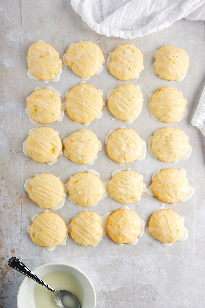 overhead view of freshly glazed Pineapple Cream Cheese Cookies on waxed paper