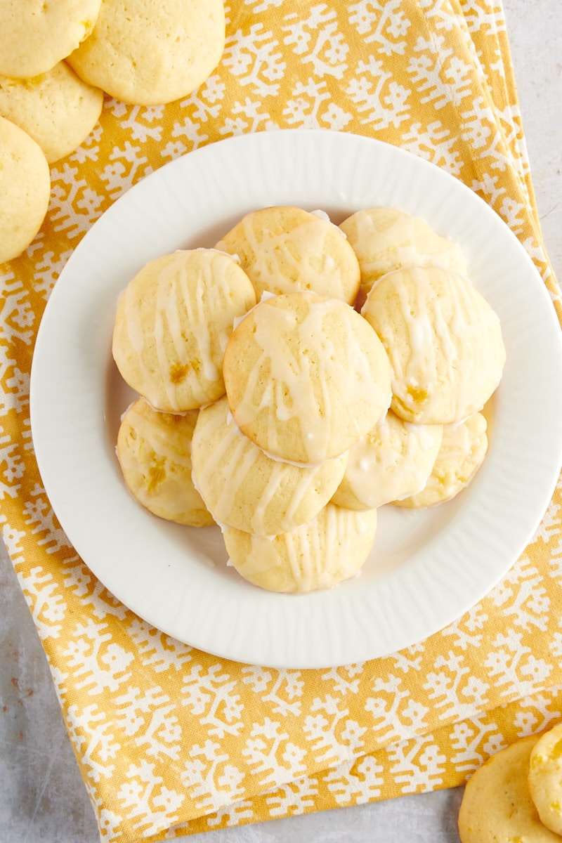 overhead view of Pineapple Cream Cheese Cookies on a white plate sitting on top of a yellow and white napkin